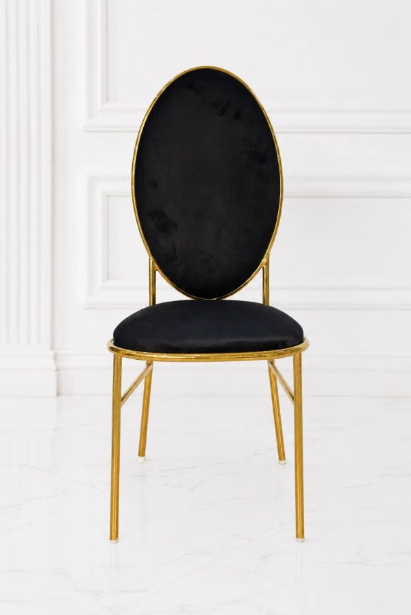 Luxury black velvet dining chair with gold metal frame and oval backrest.