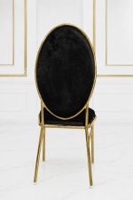 Luxury black velvet dining chair with gold metal frame and oval backrest.