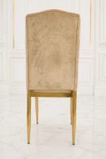 Luxury beige velvet dining chair with button-tufted high back and gold metal legs.