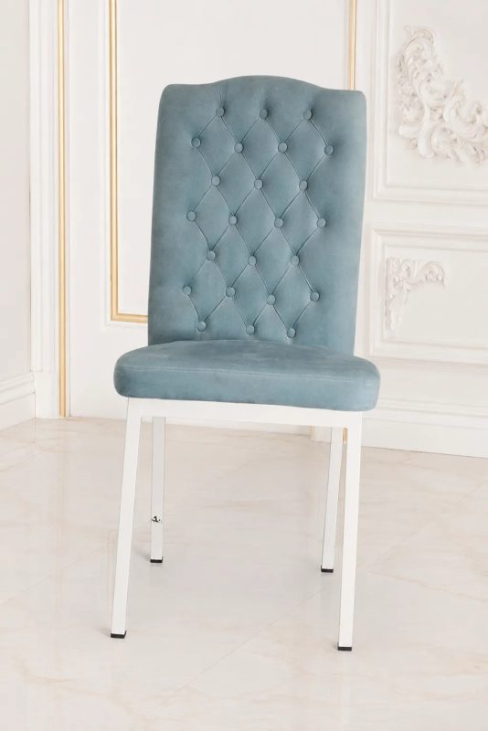 Light blue velvet dining chair with high back and white metal legs.