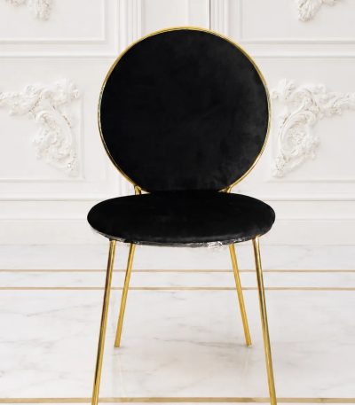 Luxury black velvet dining chair with round back and gold metal frame.