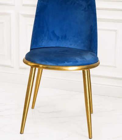 Royal blue velvet dining chair with polished gold metal legs.