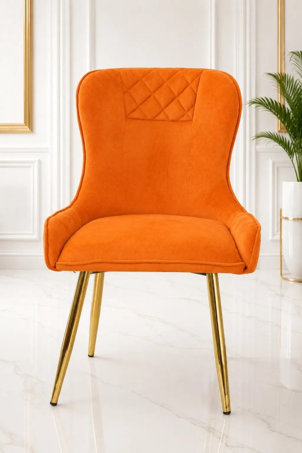Luxury orange velvet dining chair with gold metal legs.